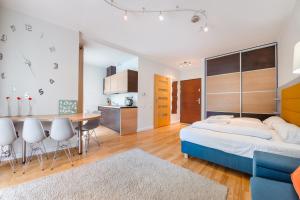 a bedroom with a large bed and a kitchen at Leśne Zacisze, Sun & Snow in Świnoujście +34 photos