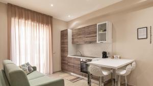 a kitchen with a white table and chairs in a room at Le Tre More in Giardini Naxos