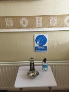a small white table with a water bottle on it at The Harbour Inn B&B Larne in Larne