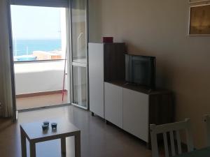 sala de estar con TV, mesa y ventana en Riva al Mare Flat, en Sestri Levante