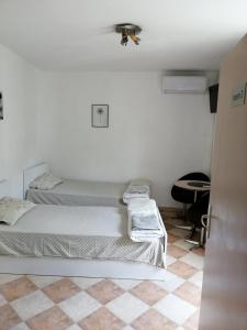 um quarto branco com duas camas e uma mesa em Пай Хост em Plovdiv