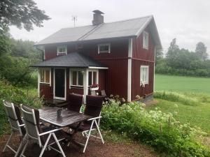 a red house with a table and chairs in front of it at Villa Tuomiranta in Sannäs
