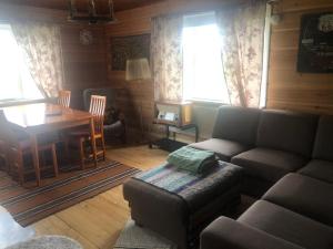 sala de estar con sofá y mesa de comedor en Villa Tuomiranta, en Sannäs