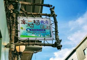 um sinal pendurado do lado de um edifício em Xincun Seed Homestay em Anping