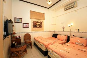 um quarto com 2 camas, um sofá e uma televisão em Xincun Seed Homestay em Anping
