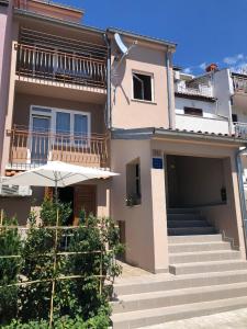 a house with stairs and an umbrella in front of it at Apartment Blue in Poreč