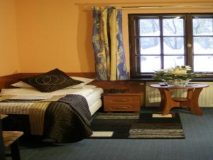ヴロツワフにあるPensjonat Rezydencja Parkowaのベッドルーム1室(ベッド1台、テーブル、窓付)