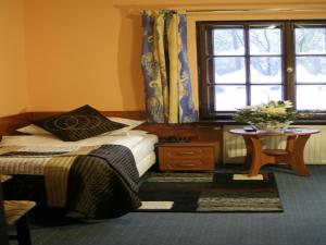 a bedroom with a bed and a table and a window at Pensjonat Rezydencja Parkowa in Wrocław