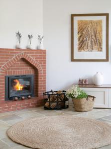 a living room with a brick fireplace and a rug at Casale Panayiotis in Kalopanayiotis
