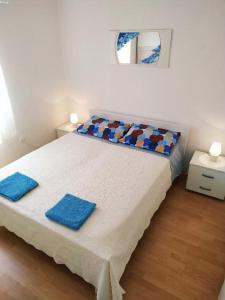 a bedroom with a bed with two blue towels on it at APARTMANI INES RABAC in Rabac