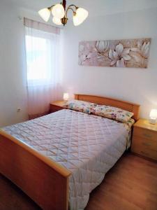 a bedroom with a bed and a painting on the wall at APARTMANI INES RABAC in Rabac