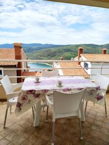 a white table and chairs on a balcony with a view at APARTMANI INES RABAC in Rabac