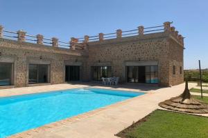 a house with a swimming pool in front of it at Villa ChezMoi in Oulad Tayeb