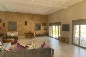 a living room with a couch and a table at Villa de luxe avec piscine privée sans vis à vis in Oulad Tayeb