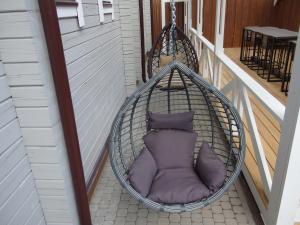 a hanging hammock with a purple pillow in a porch at Shuvalovskoye Podvorye in Saint Petersburg