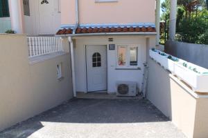 een ingang naar een huis met een witte deur bij Apartment Frleta in Umag