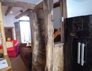 a room with a wooden wall with a refrigerator at Inglenook Cottage in Crediton