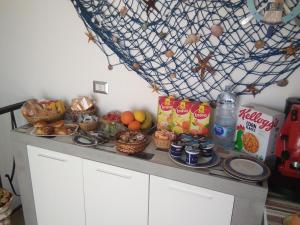 un comptoir recouvert de paniers de fruits et de collations dans l'établissement B&B La Casa di Pino, à Lampedusa