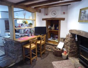 a room with a desk and a stone fireplace at Inglenook Cottage in Crediton