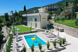 uma piscina numa villa com cadeiras e um carro alegórico amarelo em Villa Perla with swimming pool, Lovran - Opatija em Lovran
