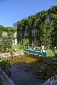 einen Garten mit einem Teich vor einem Gebäude in der Unterkunft Green Spirit Hotel in Regensburg