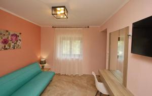 a living room with a green couch and a television at Panos House in Koinyra