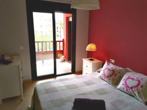1 dormitorio con 1 cama y puerta a un balcón en Apartamento de lujo en Residencial El Mocan, en Palm-mar