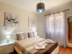 a bedroom with a bed with two towels on it at Casa Del Sol by LovelyStay in Relógio do Poiso +19 photos