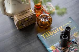 a book and a camera on a table with a book at De Nieuwe Warande in Tilburg