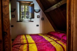 Cama en habitación con ventana en Alpeggio Pruno, en Corfino