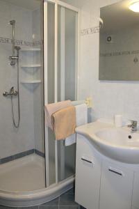 een witte badkamer met een wastafel en een douche bij Apartment Frleta in Umag +6 foto's