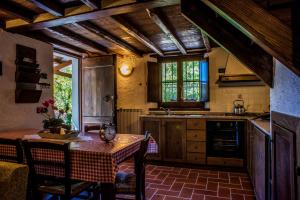 Alpeggio Pruno في Corfino: مطبخ مع طاولة وكراسي وطاولة ومطبخ مع طاولة