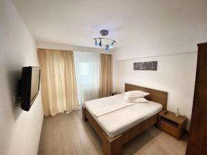 Dormitorio pequeño con cama y TV en ”Modern Apartment” Old City Constanta en Constanza
