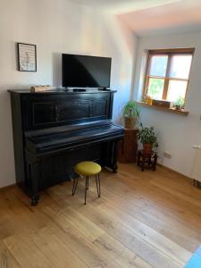 a black piano in a living room with a stool at Apartment 2 Große Brüdergasse in Bautzen