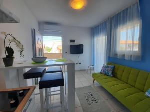 a living room with a green couch and a table at Villa Doris YourCroatiaHoliday in Premantura