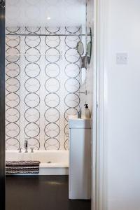 a bathroom with a tub and a sink and a toilet at The Arches Apartments in Barrow in Furness