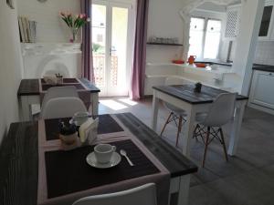 a kitchen and living room with a table and chairs at Maison Kainà in Olbia