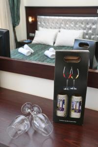 a gift box with wine glasses on a table next to a bed at Philoxenia Village Hotel-Studios in Pefkochori
