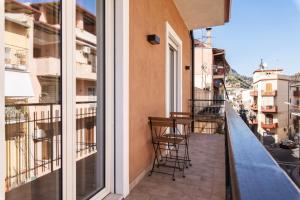 a balcony with chairs and a table on a building at Le Tre More in Giardini Naxos