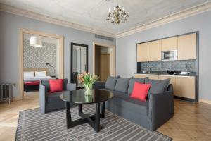 a living room with a couch and a table with red pillows at Neiburgs Hotel in Riga