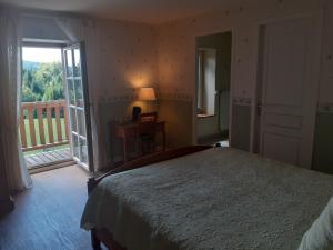 a bedroom with a large bed and a balcony at les accacias in Moyenmoutier