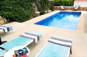 a swimming pool with two lounge chairs and a swimming pool at San Colomban in Sant Lluis +11 photos