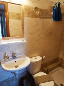 een badkamer met een wastafel, een toilet en een spiegel bij Anastasia in Áno Lekhónia
