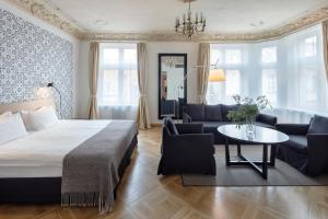 a bedroom with a bed and a couch and a table at Neiburgs Hotel in Rīga
