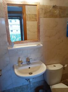 a bathroom with a sink and a toilet and a mirror at Anastasia in Áno Lekhónia