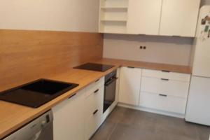 a kitchen with white cabinets and a wooden counter top at Apartament Pod Taborem in Niedzica Zamek