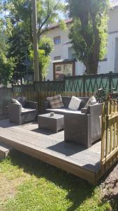 a wooden deck with couches and chairs on it at Pensione Bianca in Bardonecchia