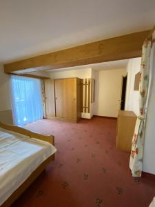 a hotel room with a bed and a window at Harpfner in Finkenberg