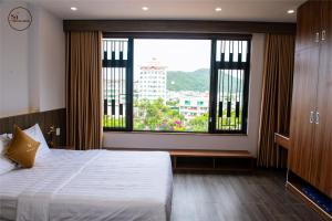 a bedroom with a bed and a large window at Sơn Hà Hotel in Quy Nhon