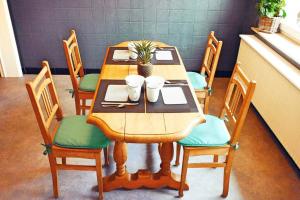 une table en bois avec des chaises et une table avec une plante. dans l'établissement Chez Sarah, à Stavelot